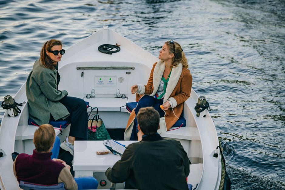 A small group out on a boat on an Amsterdam canal