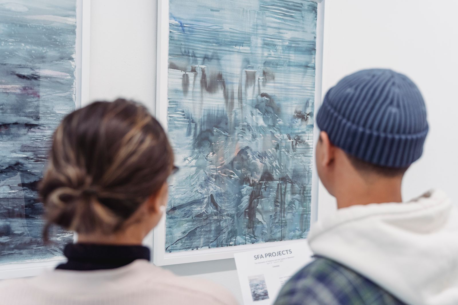 Visitors looking at abstract paintings together in a gallery
