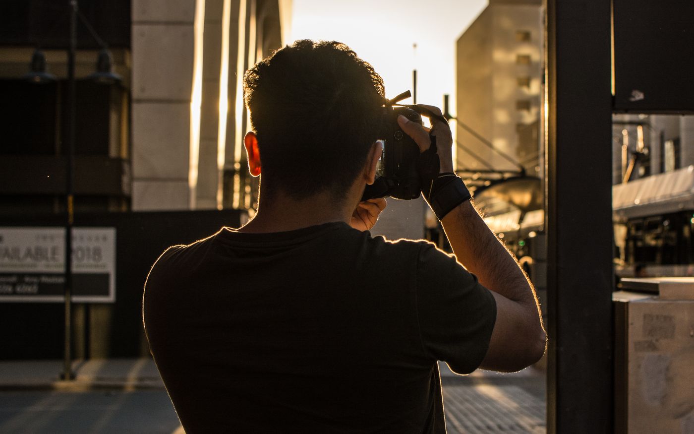 A photographer shooting a city street at golden hour