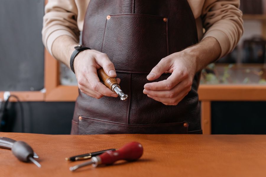 A craftsman holding a leatherworking tool