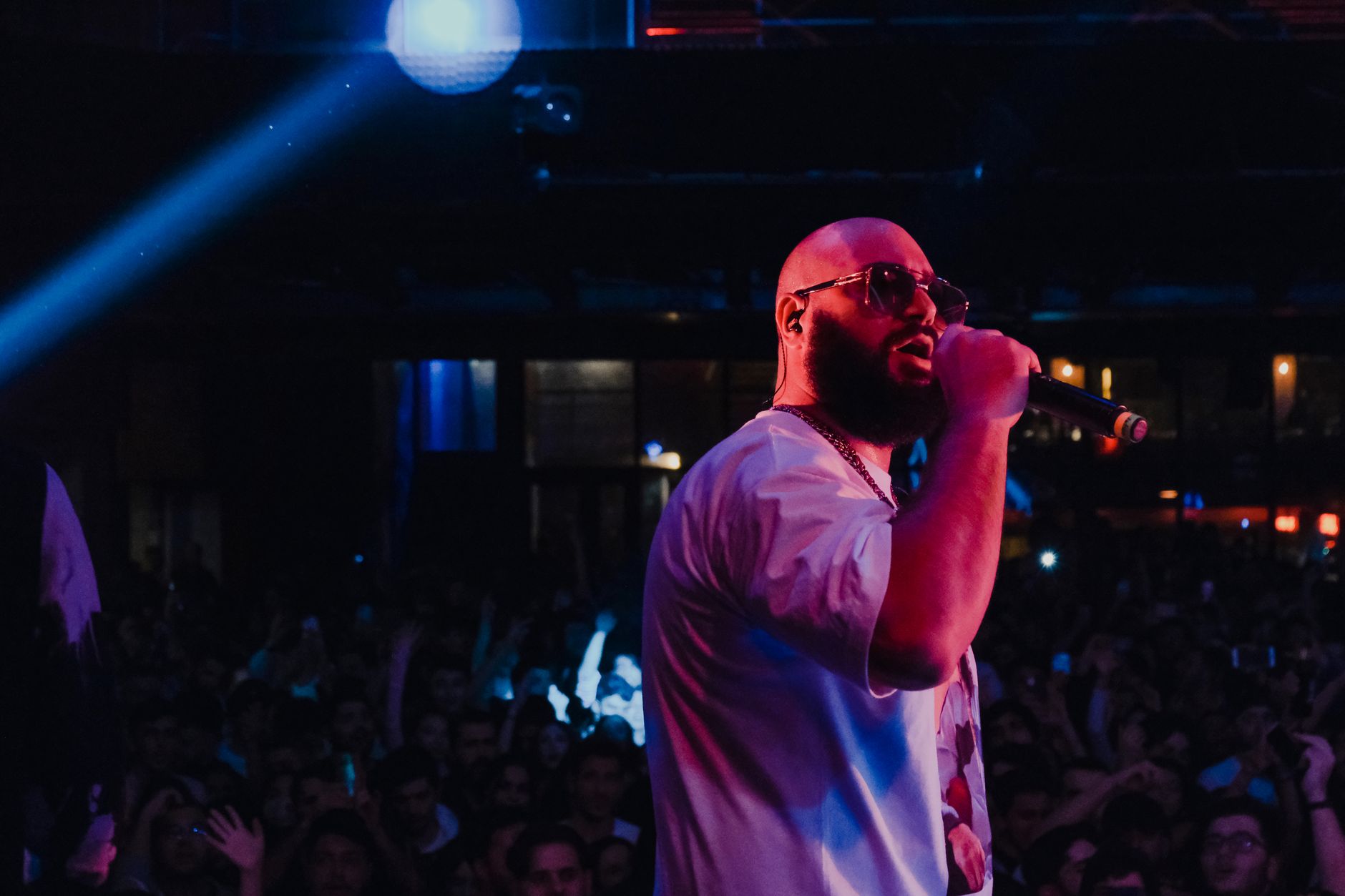 A performer on stage with a microphone in front of a crowd