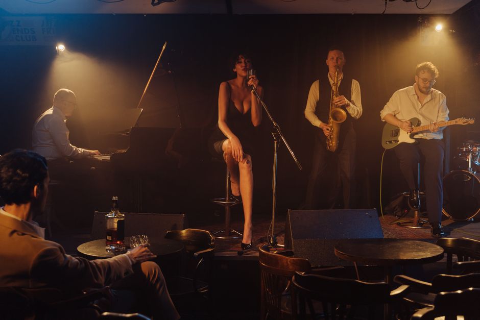 A four-piece playing to a small room, drinks on the tables